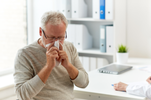 Man is blowing his nose